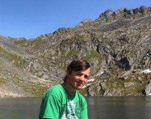Photo of Kyle Youngs with a lake and mountains in the background